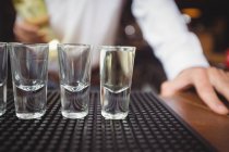 Primo piano di bicchierini vuoti sul bancone del bar al bar — Foto stock