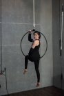 Porträt einer Turnerin, die im Fitnessstudio auf Reifen turnt — Stockfoto