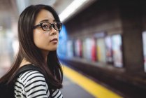 Молода жінка чекає на поїзд на вокзалі — стокове фото