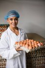 Ritratto di personale femminile con vassoio per uova in fabbrica — Foto stock