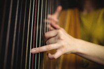 A meio da seção da mulher tocando uma harpa na escola de música — Fotografia de Stock