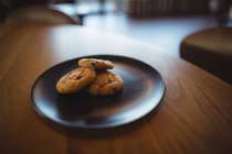 Three cookies in plate at cafeteria — Stock Photo