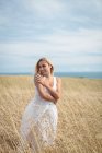Smiling blonde woman standing in field — Stock Photo