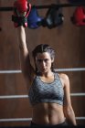 Portrait of woman in boxing gloves at fitness studio — Stock Photo