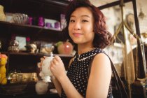 Портрет стильної жінки, яка вибирає чайний горщик в антикварних магазинах — стокове фото