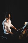 Belle femme jouant un piano dans un studio de musique — Photo de stock