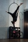 Gimnasta realizando gimnasia en el aro en el gimnasio - foto de stock