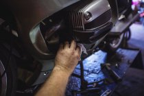Hand des Mechanikers schließt Öltank des Motorrads in Werkstatt — Stockfoto