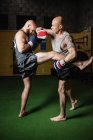 Вид сбоку двух тайских боксеров, дерущихся в спортзале — стоковое фото