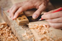 Mains d'homme travaillant sur une planche de bois au chantier naval — Photo de stock