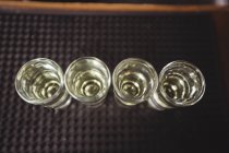 Primer plano de tequila en vasos de chupito en el mostrador de bar en el bar - foto de stock