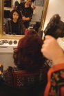 Friseur föhnt Kundenhaare im professionellen Salon — Stockfoto