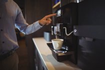Mittelteil des Geschäftsmannes bereitet Kaffee in Kaffeemaschine in Cafeteria zu — Stockfoto