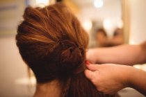 Rückansicht einer Frau, die ihre Haare im Salon frisiert — Stockfoto