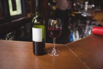 Close-up de vidro com vinho tinto no balcão do bar no bar — Fotografia de Stock