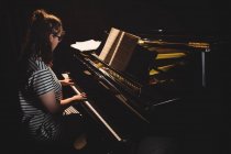 Studente donna che suona il pianoforte in uno studio — Foto stock