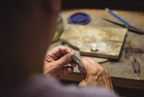 Nahaufnahme einer Handwerkerin mit einer Zange in der Werkstatt — Stockfoto