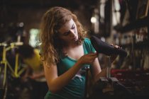 Mechanic examining bicycle in workshop — Stock Photo