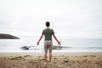 Vista posteriore dell'uomo in piedi sulla spiaggia — Foto stock
