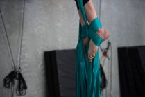 Close-up de ginasta exercitando em corda de tecido azul no estúdio de fitness — Fotografia de Stock