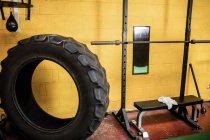 Tire and workout bench in empty fitness studio — Stock Photo
