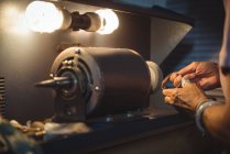 Manos de artesana trabajando en una máquina en taller - foto de stock
