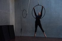 Jovem mulher realizando ginástica no aro no estúdio de fitness — Fotografia de Stock