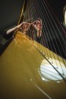 Attentive woman playing a harp in music school — Stock Photo