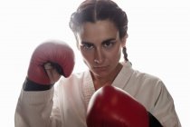 Portrait of confident woman in boxing gloves at fitness studio — Stock Photo