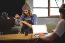 Kellnerin bereitet Kaffee am Tresen in Werkstatt zu — Stockfoto