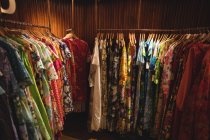 Female clothes arrangement on hangers in vintage boutique — Stock Photo