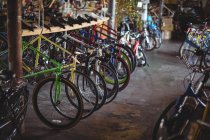 Bicicletas multicolores dispuestas en fila en el taller - foto de stock