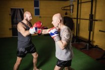 Guapos dos boxeadores tailandeses practicando boxeo en el gimnasio - foto de stock