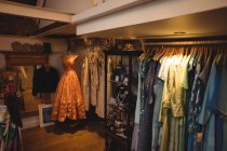 Female clothes arrangement on hangers in vintage boutique — Stock Photo