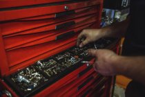 Mechaniker demontiert Muttern aus Werkzeugkiste in Werkstatt — Stockfoto