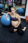 Retrato de mulher grávida segurando sua barriga no ginásio — Fotografia de Stock