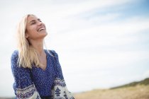 Attractive blonde woman laughing in field — Stock Photo