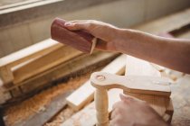 Hombre trabajando sobre una tabla de madera en el astillero - foto de stock