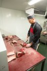Boucher découper la carcasse de porc avec un couteau dans la boucherie — Photo de stock