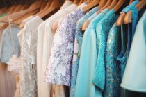 Vari vestiti colorati su una gruccia al negozio boutique — Foto stock