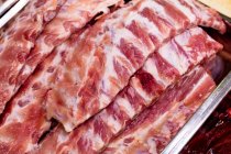 Fette di carne rossa al banco espositivo in macelleria, primo piano — Foto stock