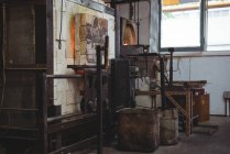 Estação de trabalho vazia e forno na fábrica de sopro de vidro — Fotografia de Stock