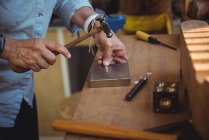 Mid-section of craftswoman using hammer in workshop — Stock Photo