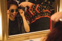 Eccitato donna in occhiali da sole ottenere i suoi capelli fatto in un salone di parrucchiere professionale — Foto stock