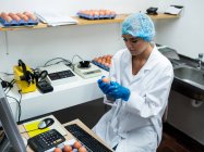 Aufmerksame Mitarbeiterinnen untersuchen Ei in Eierfabrik — Stockfoto