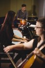 Grupo de estudiantes tocando varios instrumentos en un estudio - foto de stock