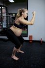 Femme enceinte faisant de l'exercice dans la salle de gym — Photo de stock