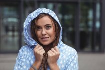 Beautiful woman in windcheater looking at camera during rain — Stock Photo