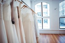 Vários vestido de noiva pendurado na linha de roupas em uma loja em estúdio — Fotografia de Stock