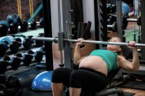 Вагітна жінка скасування ваги в тренажерний зал — стокове фото